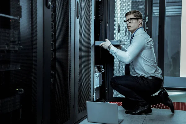 Security guard in a blue shirt replacing the equipment in an intelligence agency