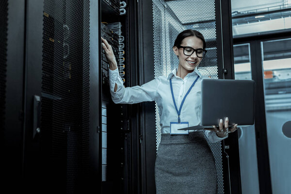 Темноволосая красивая женщина в юбке, стоящая рядом с оборудованием
