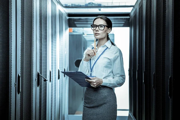 Mörkhårig kvinna i glasögon känsla tankeväckande på arbetsplatsen — Stockfoto