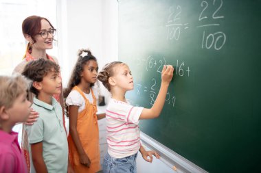 Akıllı kız matematik dersi sırasında tahtaya numaraları yazma