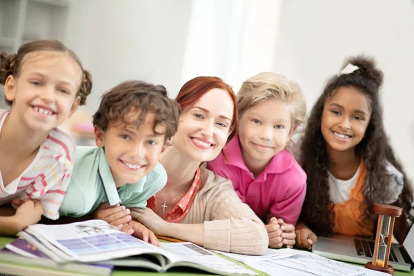 Strahlende Schüler stehen in der Nähe ihres freundlichen Lehrers — Stockfoto