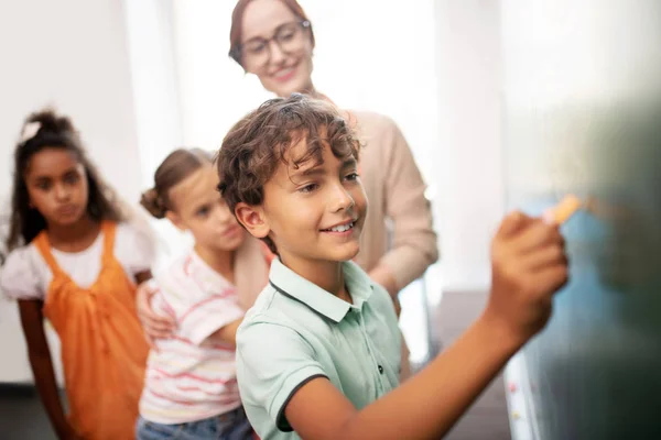 Niño llegando a pizarra durante la clase de matemáticas —  Fotos de Stock