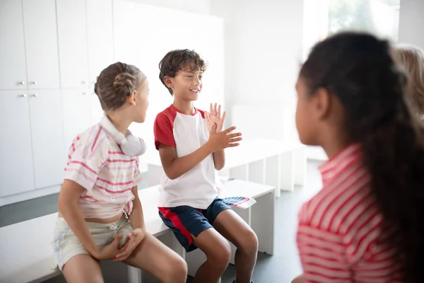 Jungen und Mädchen kommunizieren vor dem Sport in der Umkleidekabine — Stockfoto