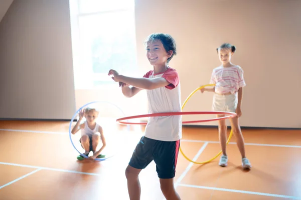 Chico riendo mientras rodando hula-hoop por primera vez — Foto de Stock