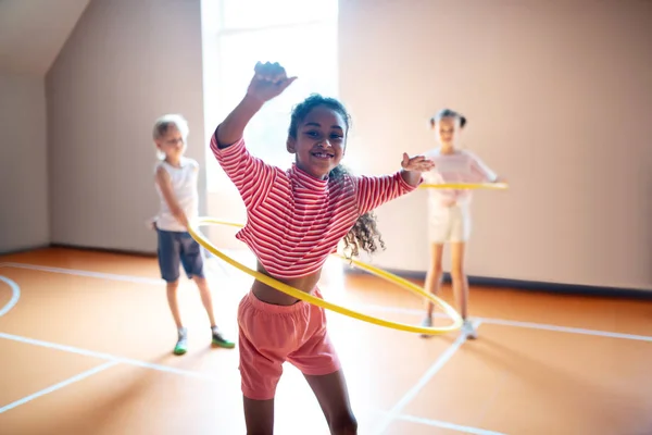 Cheerful curly girl enjoying active PE lesson