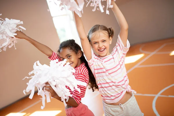 Girls wearing sport clothing laughing while practicing cheerleading — Stock Photo, Image