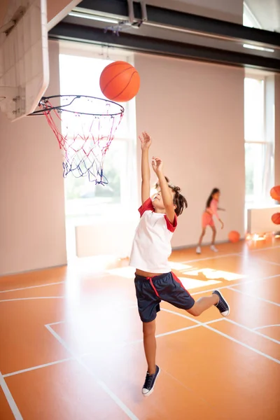 Chico saltando alto mientras entrena y juega baloncesto — Foto de Stock