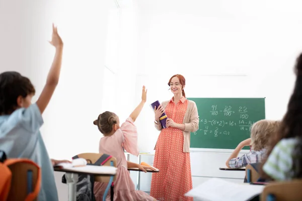 Рыжеволосая учительница улыбается, довольствуясь своими учениками — стоковое фото