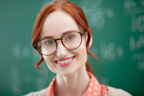 Teacher with natural makeup standing near blackboard — Stock Photo, Image