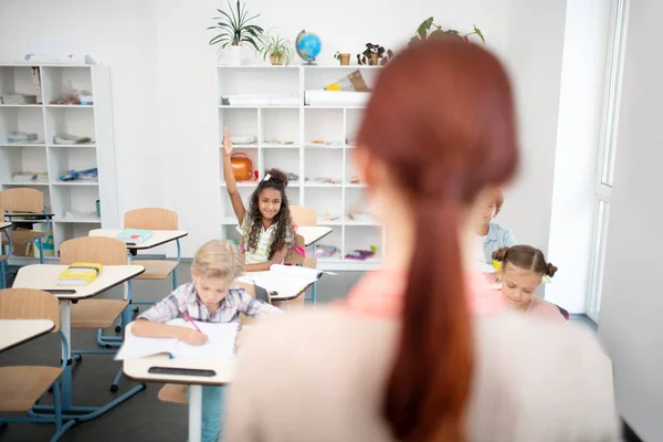 Mörkhyade Girl Raising hand samtidigt ha svar på frågan — Stockfoto