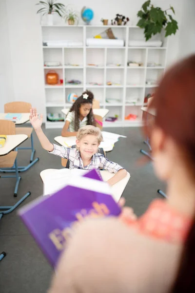 小学生举手，而有回答老师 — 图库照片