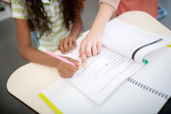 Tampilan atas guru menunjukkan kesalahan sementara gadis menulis tes — Stok Foto