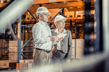 Her iki elinde gadget tutan ciddi erkek kişi