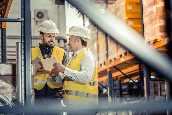 Pleased grey-haired man looking at his colleague