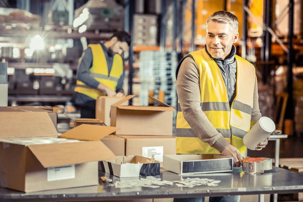 Positief verrukt mannelijke persoon verpakking waren in vak — Stockfoto