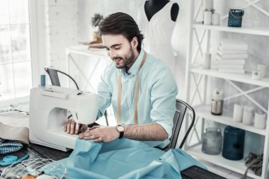 Tasarım stüdyosunda çalışan genç sakallı adam memnun