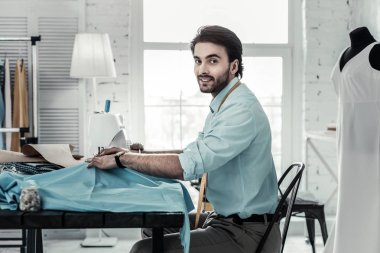 İşyerinde oturan yakışıklı genç stilist