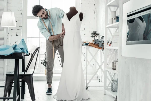 Konzentrierter bärtiger Mann näht Kleid für Kundin — Stockfoto
