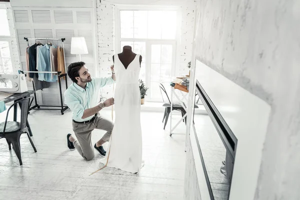 Positiver entzückter brünetter Mann mit Blick auf weißes Kleid — Stockfoto