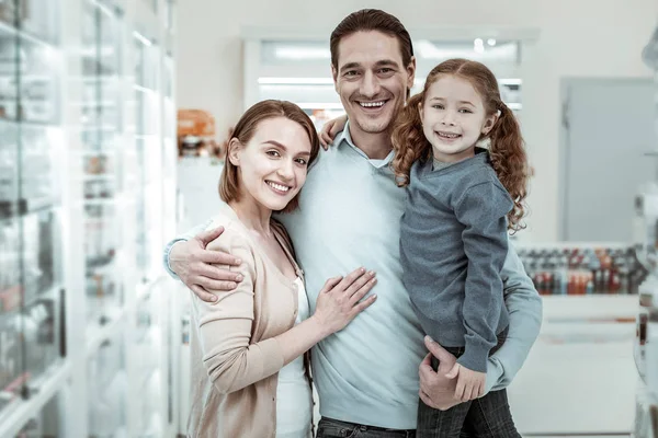 Happy family cuddling and smiling in the pharmacy — Stock Fotó