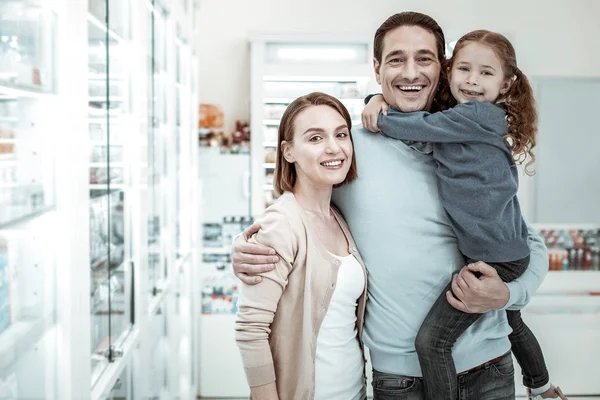Cheerful family smiling and embracing each other in the drugstore — Stock Fotó