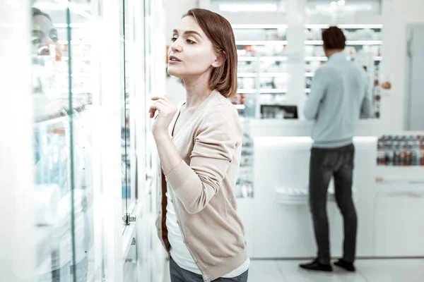 Een mooie dame kiezen van de vitaminen met haar vriendje op de achtergrond — Stockfoto