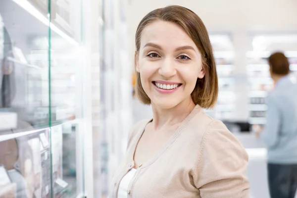 Темноволосая сияющая привлекательная леди, улыбающаяся в аптеке . — стоковое фото