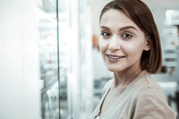 En trevlig kort haired kvinna ser fredligt på apoteket. — Stockfoto