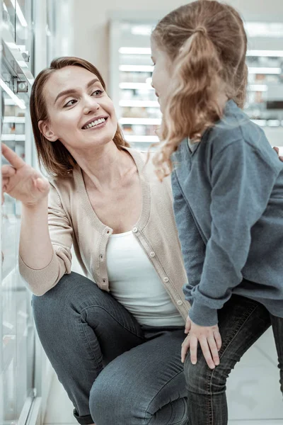 Cuidar a la madre compartiendo una risa con la niña en la tienda de farmacias — Foto de Stock