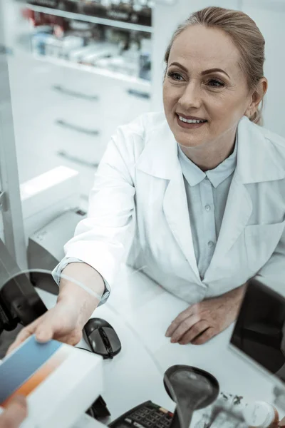 Eine Drogeriearbeiterin erhält die Packung Pillen — Stockfoto