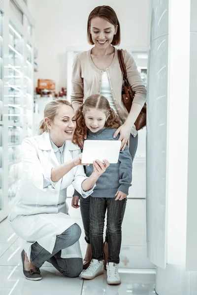 Mãe e filha olhando para o comprimido do farmacêutico curiosamente — Fotografia de Stock
