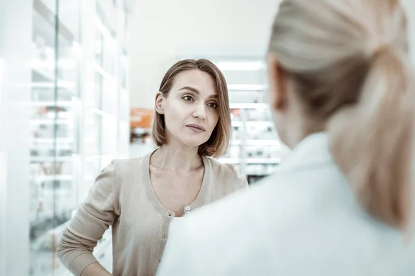 Жахливо виглядає вибаглива жінка уважно слухає фармацевта . — стокове фото