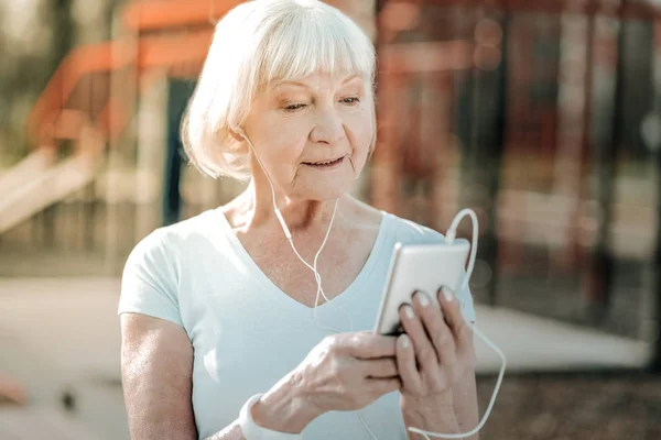 Patrząc Telefon Radiantly Uśmiechnięty Emerytowany Mam Krótkim Szarym Haicut Concernedly — Zdjęcie stockowe