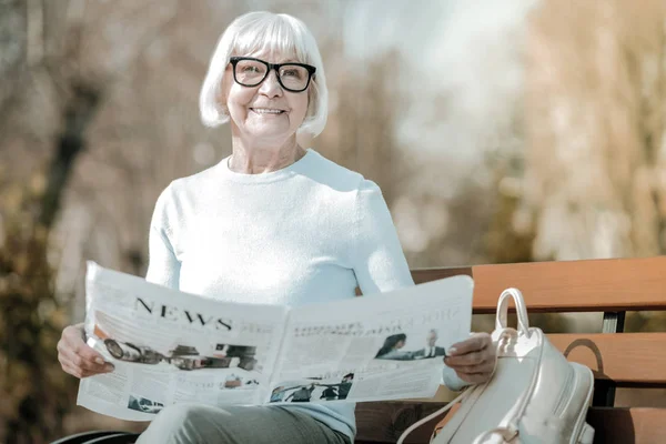 Блеск элегантной пожилой женщины держит бумагу в парке — стоковое фото