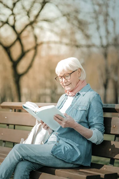 Büyüleyici yaşlı missis bir kitap zevk gözlük giyiyor — Stok fotoğraf
