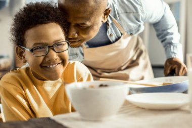 Babasının ona sevgiyle nasıl yaslandığını gösteren çocuk.