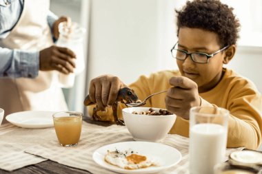 Babam ona süt dökerken masada oynayan çocuk.