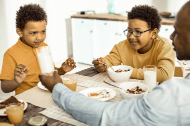 Oğullarından birinin süt içmesi gerektiğinde ısrar eden adam..