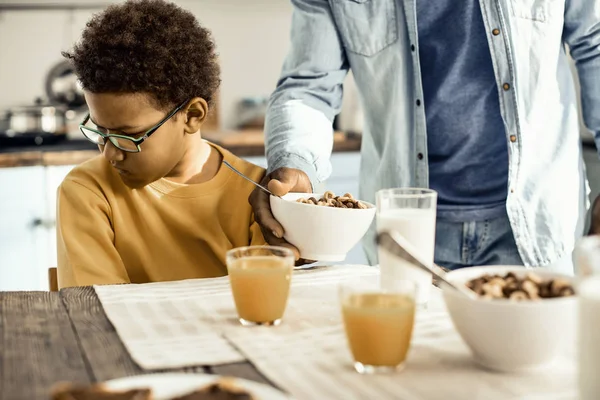 Papá le ofrece a su hijo un cereal para el desayuno, pero no quiere. . — Foto de Stock