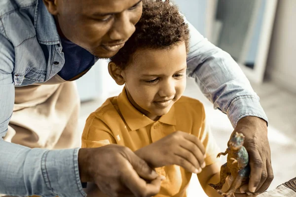 Niño y papá están explorando un dinosaurio plástico . —  Fotos de Stock