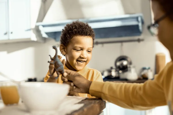 Durante el desayuno dos niños jugando con dinosaurios de juguete . — Foto de Stock