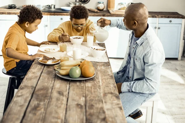 Familia de papá y dos chicos desayunando en la cocina . — Foto de Stock