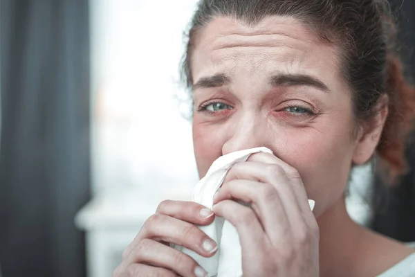 Зеленоглазый женщина сушит свой бегущий нос после сильной аллергии — стоковое фото