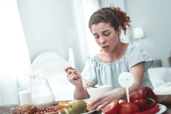 Молодая кудрявая женщина с кожной сыпью, у которой сильная аллергия на глютен — стоковое фото