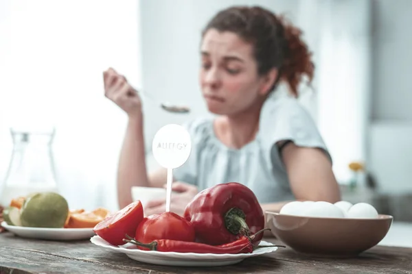 Mulher ruiva encaracolada que tem alergia a vegetais vermelhos — Fotografia de Stock