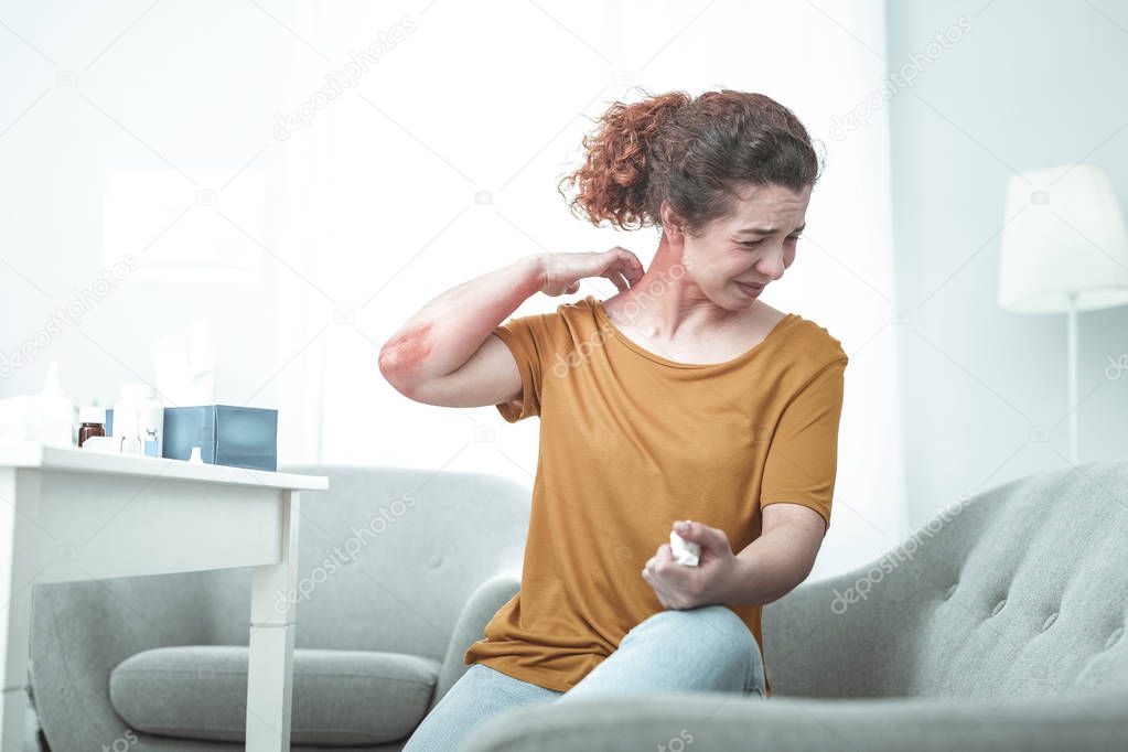 Curly woman suffering from strong allergy to dust and chemicals