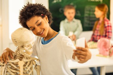 Mutlu kıvırcık saçlı uluslararası çocuk selfie fotoğraf konuşurken