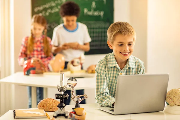 Pozitif memnun sarışın çocuk bilgisayara bakıyor — Stok fotoğraf