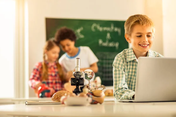 Alegre pequeño varón estudiando biología con placer —  Fotos de Stock