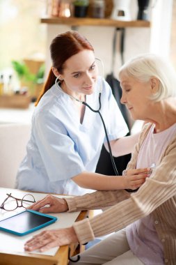 Kızıl saçlı hemşire baş ağrısı olan emekli muayene